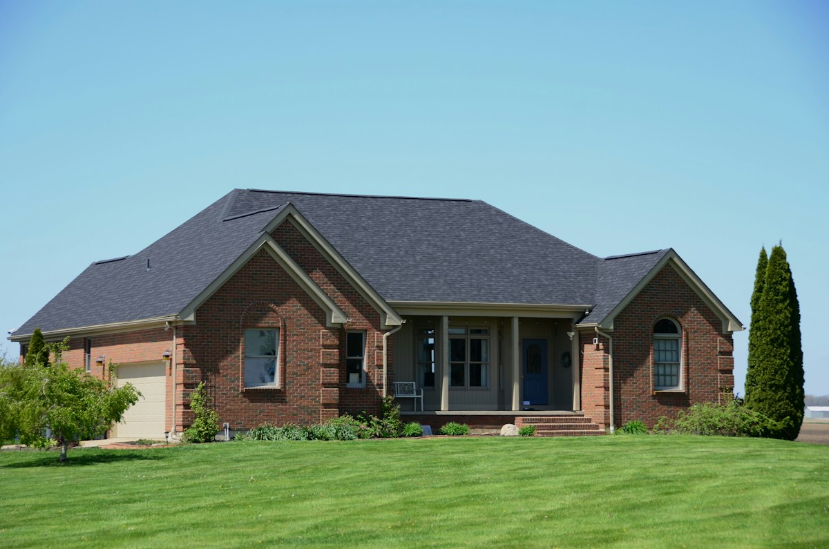 A suburban brick home with a broad lawn